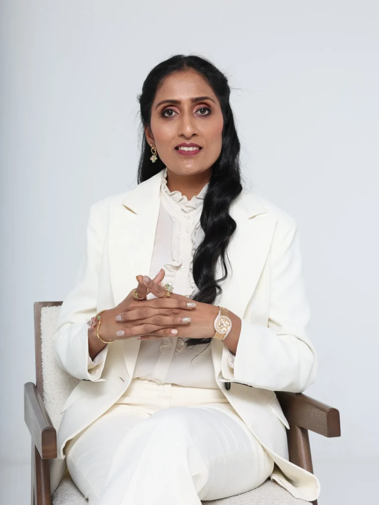 "Mamata Dhiraj Jain, Founder of 1XL Holdings, in a white tailored suit"